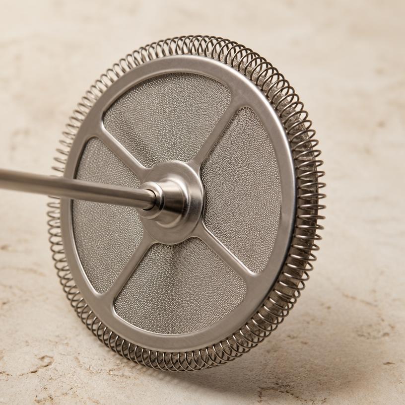 Compatify stainless steel mesh filter disc for Bodum-style French presses, shown on a stone background